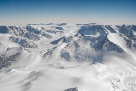 An aerial view of white mountains in Antarctica.