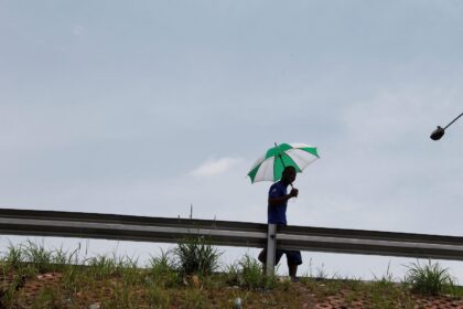 A man walking with an umbrella in hand, Lagos, Nigeria.