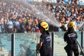 Firefighters spray water at people due to intense heat during a football game in Argentina.