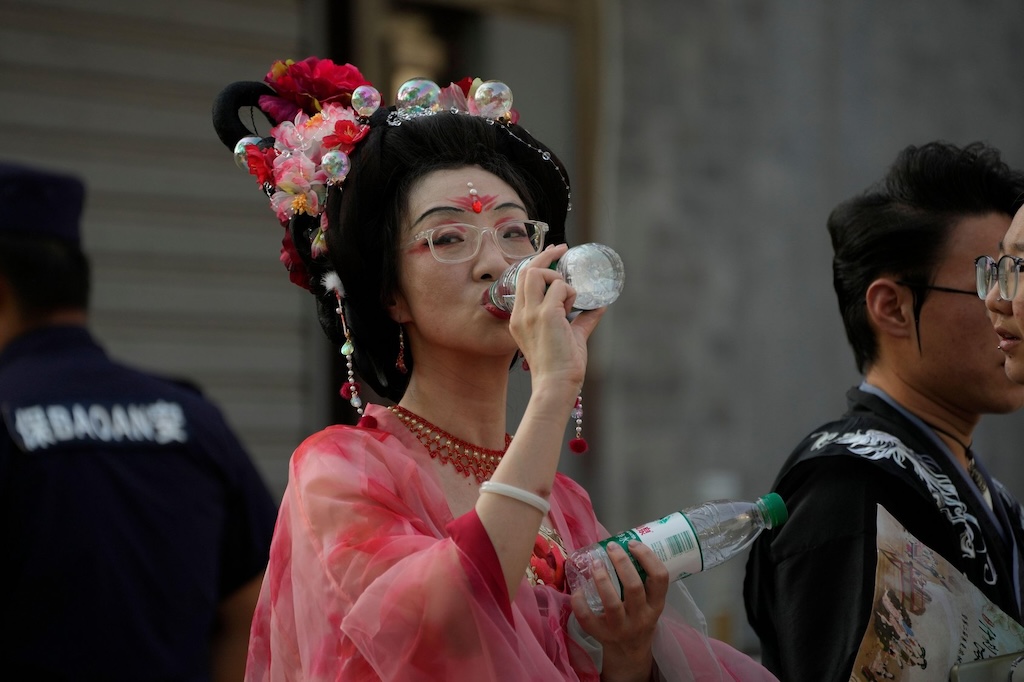 A woman wearing a traditional costume during a hot day in Beijing, China.