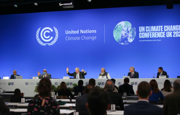 Boris Johnson makes the 1.5 degree hand gesture at COP26