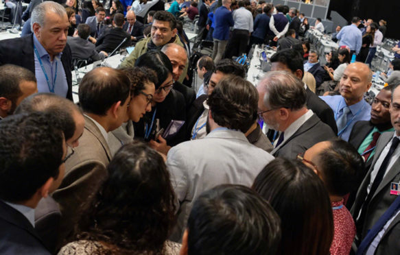 Delegates huddle during the final stages of the SBSTA closing plenary at COP25