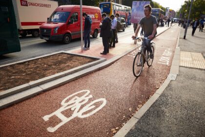 Cycling using cycle lanes on Oxford Road, Manchester.