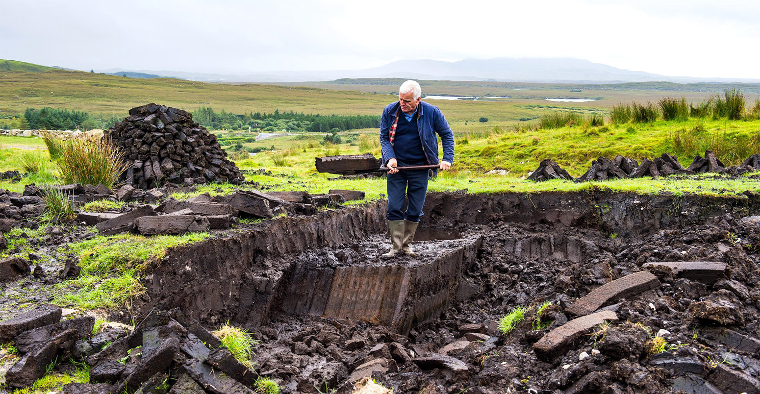 Blocks of peat being cut in Connemara National Park, Republic of Ireland. Credit: robertharding / Alamy Stock Photo.