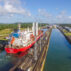 Red cargo ship transits through Gatun Locks, Panama Canal.