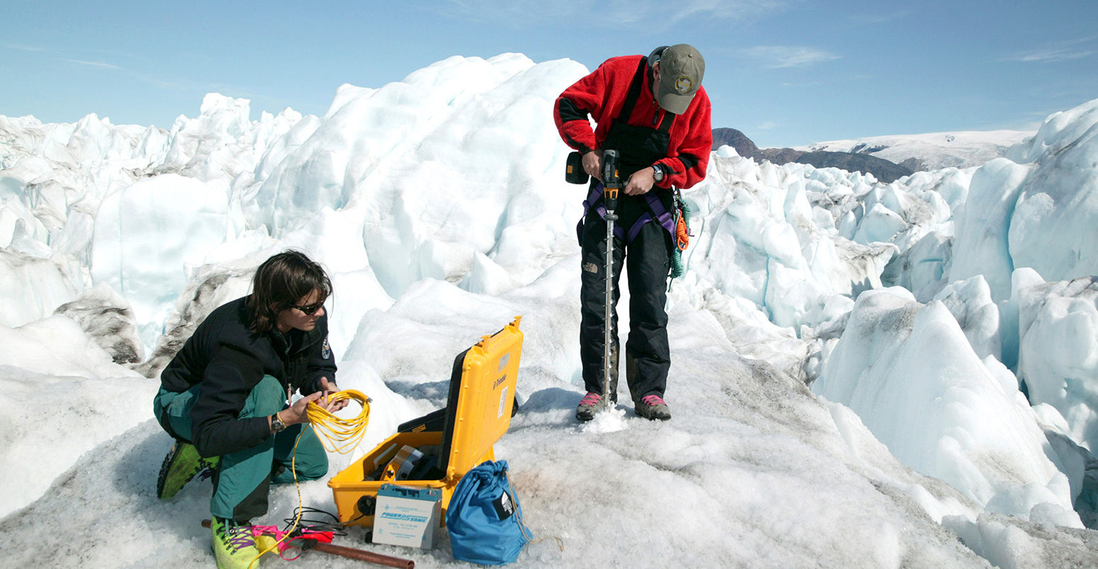 Glaciologists measuring the rate of movement on the Kangerdlussuaq glacier, Greenland. Credit: Steve Morgan / Alamy Stock Photo. DFB4EE