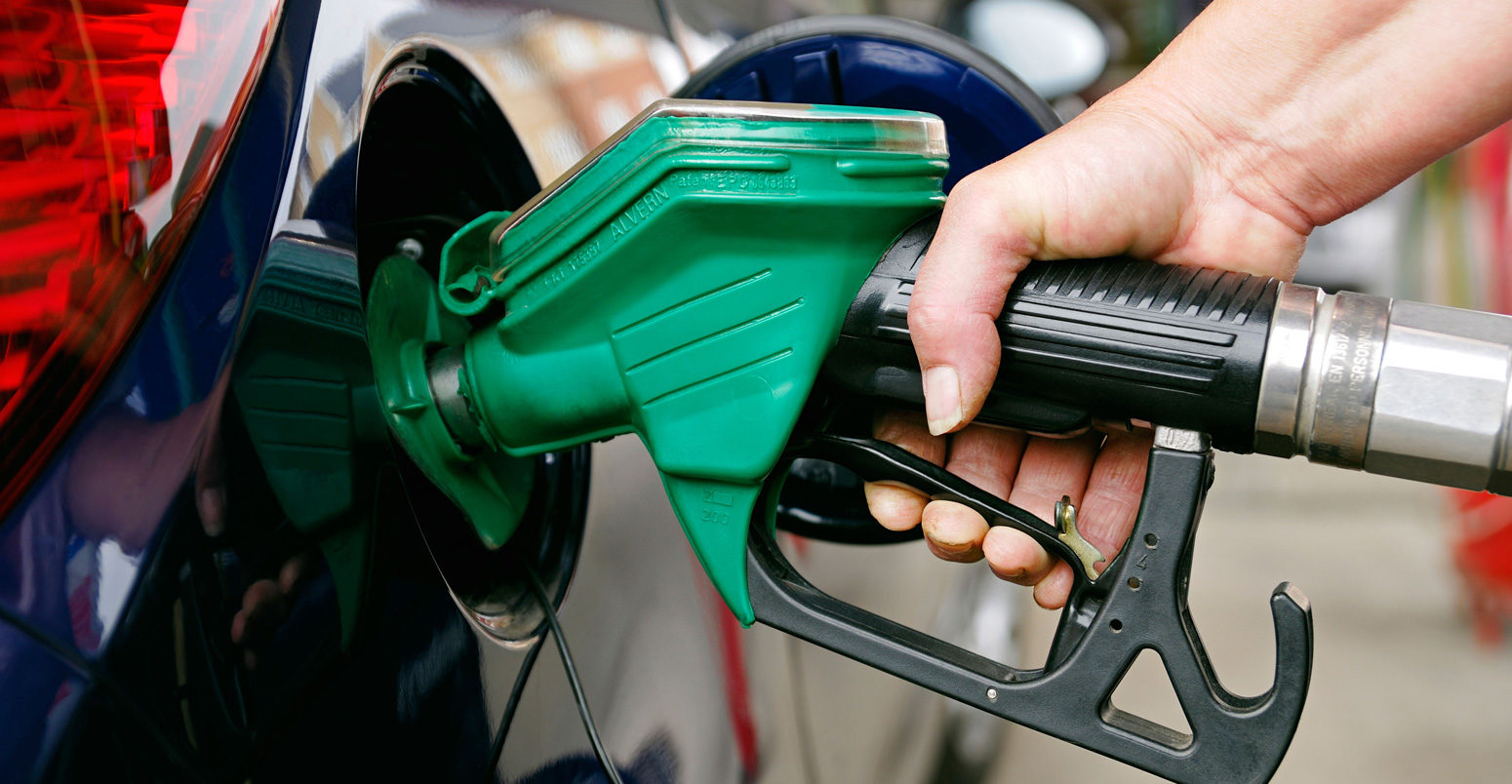 Woman Filling a Car with Unleaded Petrol, UK.